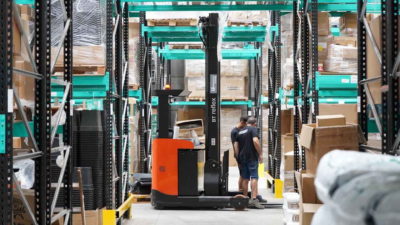 Modern fulfilment centre with warehouse shelving and workers packing ecommerce orders